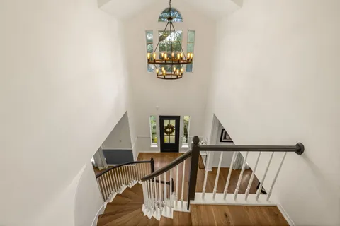 a view of staircase with railing and white walls