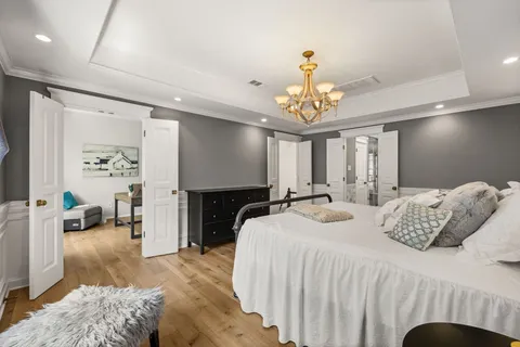 a bedroom with bed and a chandelier