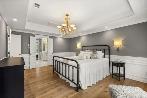 a bedroom with a bed and a chandelier