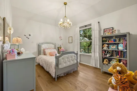 a bedroom with a bed and a chandelier