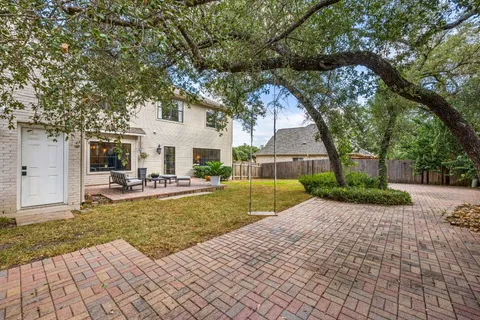 a view of a house with garden and a tree