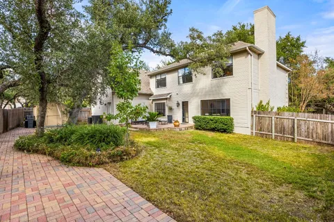 a view of a white house with a yard and potted plants