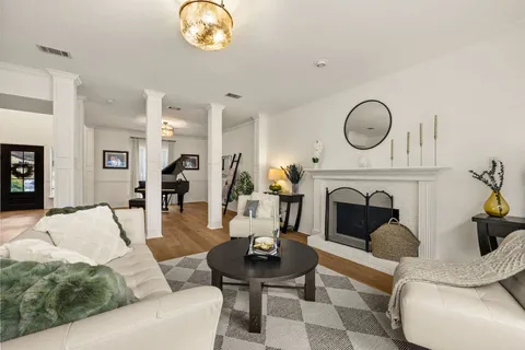 a living room with furniture a fireplace and a chandelier