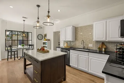 a kitchen with a sink a counter space appliances and cabinets