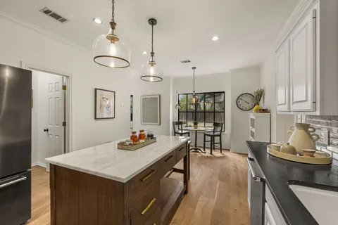 a kitchen with a table chairs stove and refrigerator