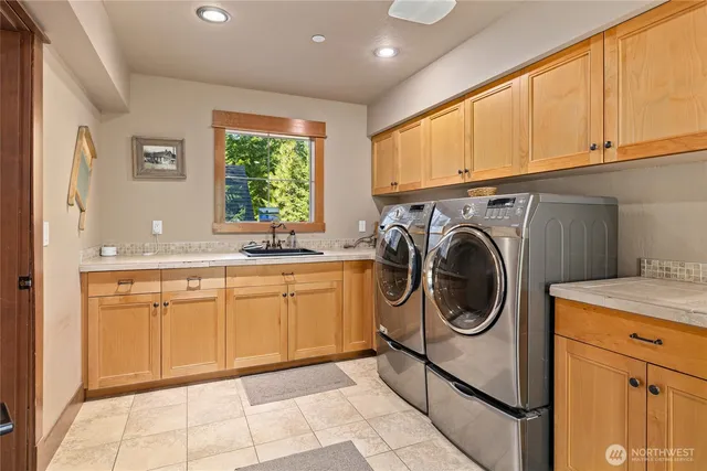 a utility room with sink dryer and washer