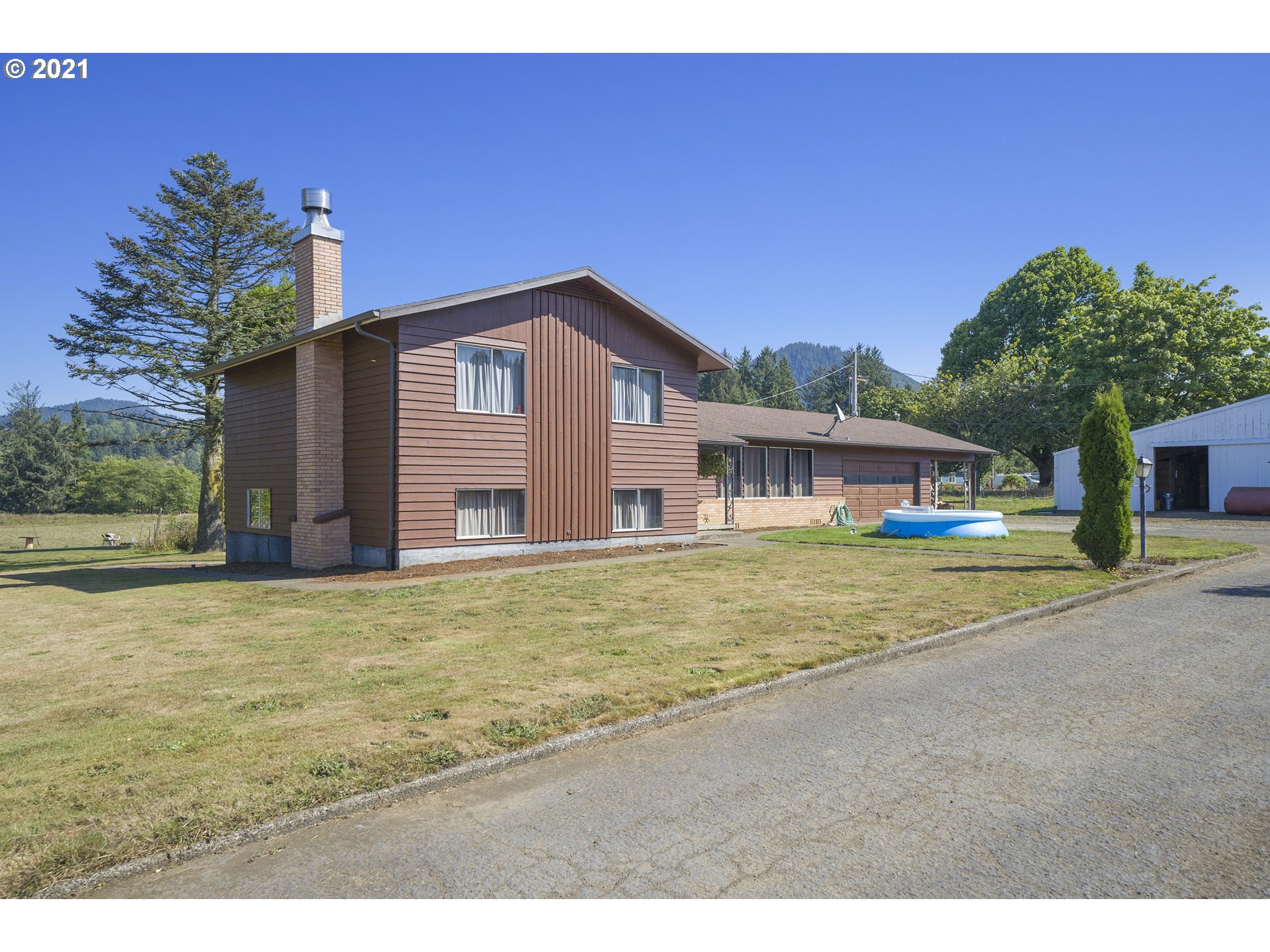 10050 Chance Road Tillamook, OR 97141 - Photo 2 of 31 a front view of a house with a garden and yard