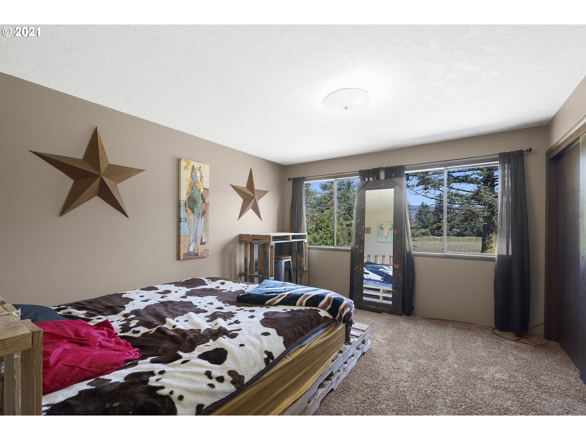 10050 Chance Road Tillamook, OR 97141 - Photo 12 of 31 a bedroom with a bed and a large window