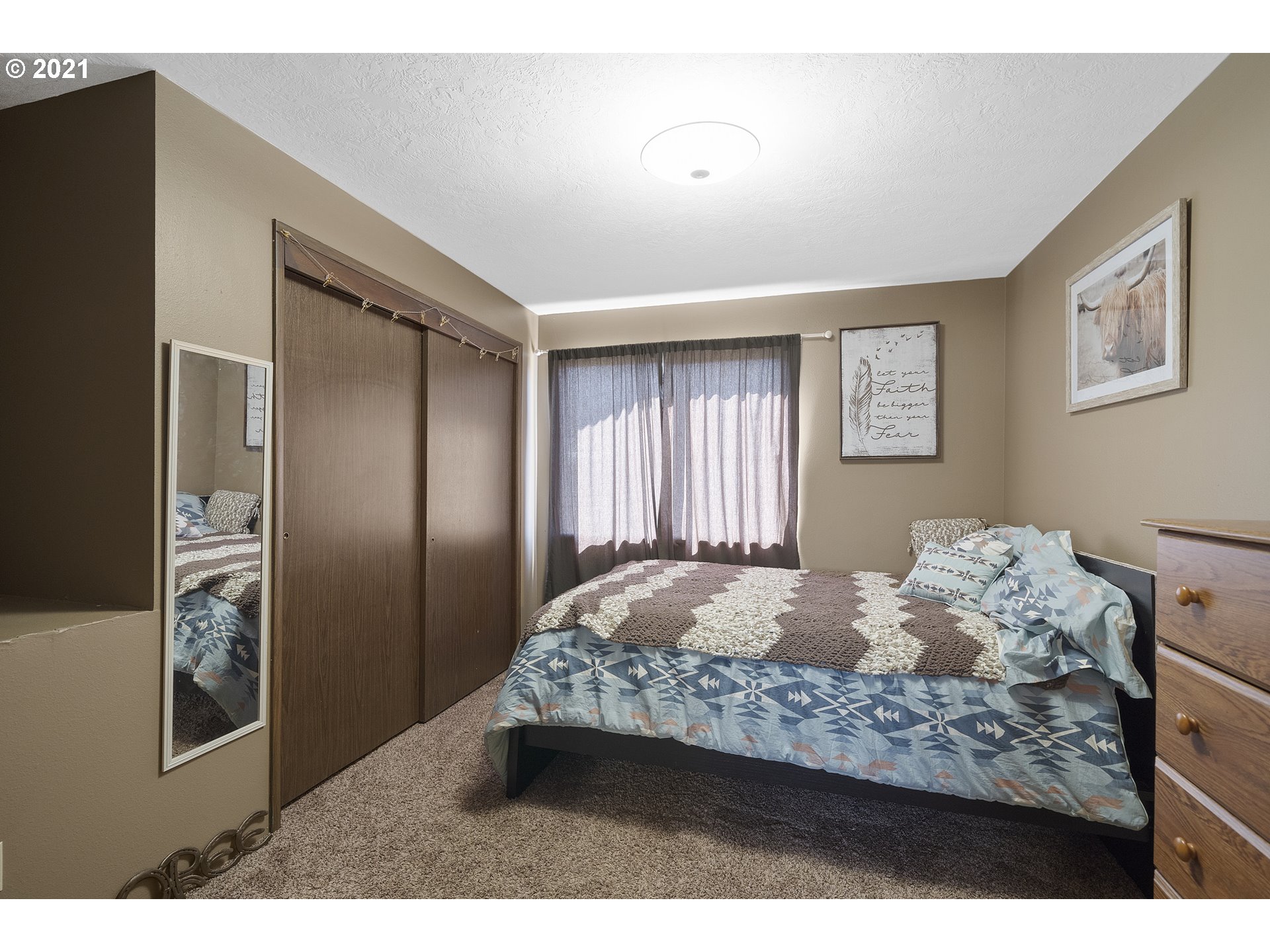 10050 Chance Road Tillamook, OR 97141 - Photo 13 of 31 a bedroom with a bed and a painting on the wall