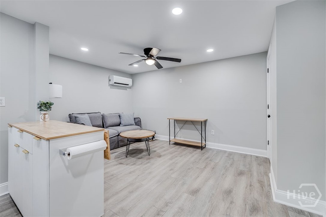 318 East 45th Street, Unit STUDIO Savannah, GA 31405 - Photo 7 of 20 Living area is furnished with a couch, coffee table, sofa table, end table, floor lamp and throws.