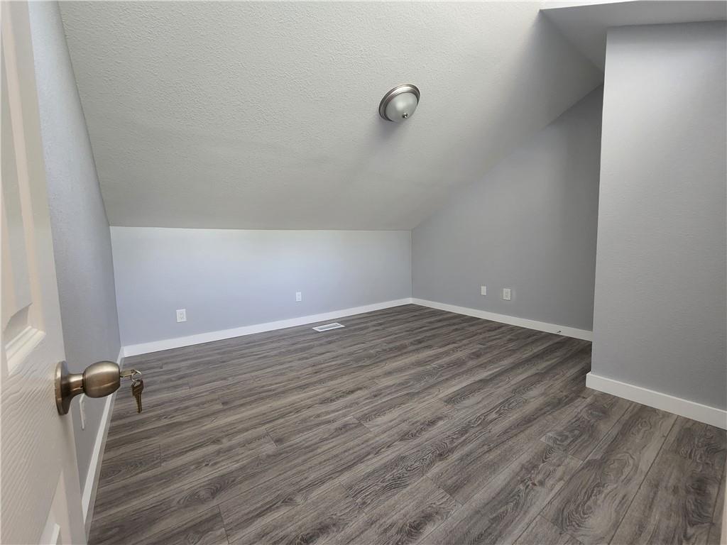 2815 Rio Grande Street, Unit 215 Austin, TX 78705 - Photo 9 of 11 An inviting attic space features sloped ceilings and durable flooring, perfect for a cozy retreat.