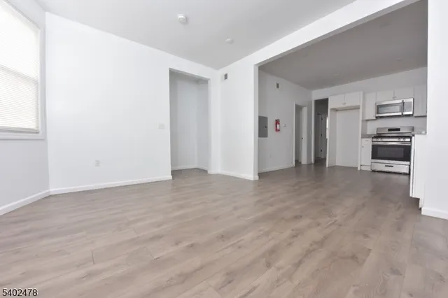 a view of a kitchen with refrigerator stove and cabinets