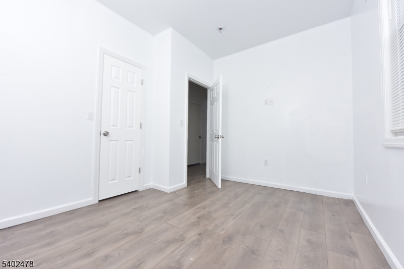 473 Grove Street, Unit 1 Irvington, NJ 07111 - Photo 5 of 17 an empty room with wooden floor