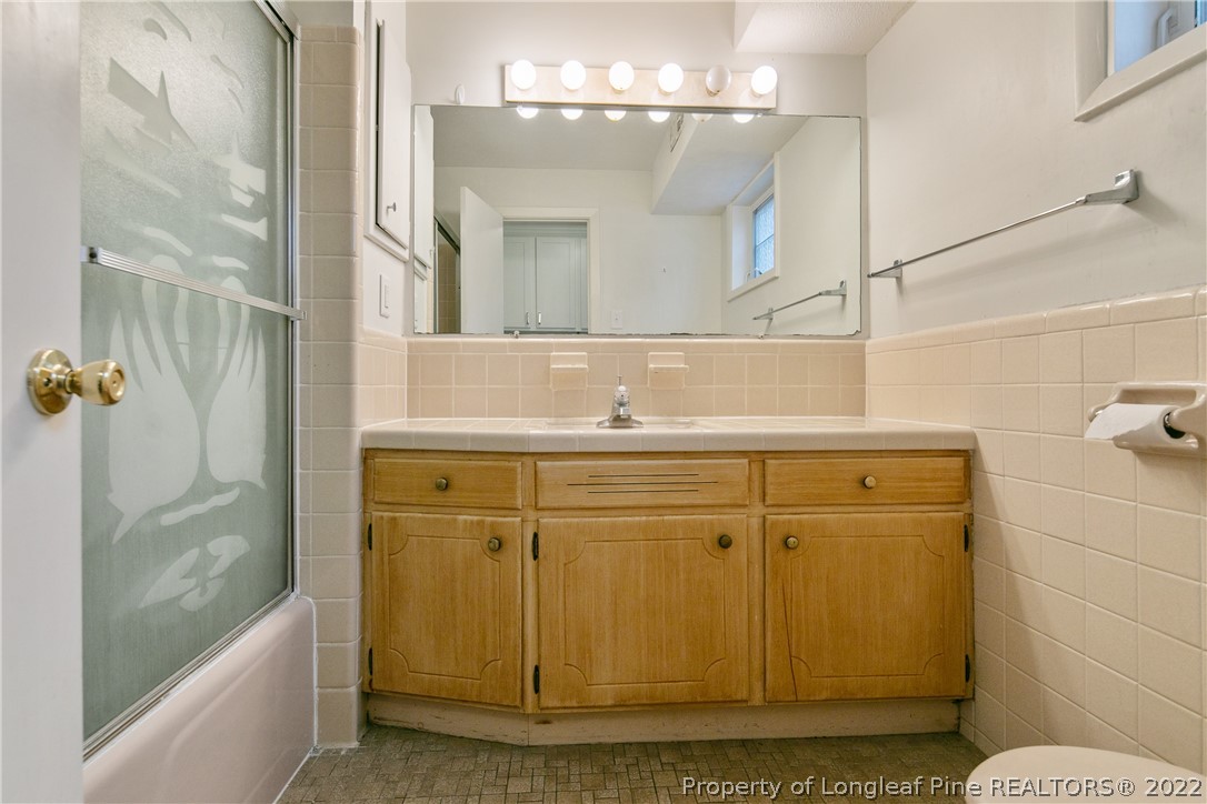 6309 Greyfield Road Fayetteville, NC 28303 - Photo 35 of 45 a bathroom with a sink and mirror