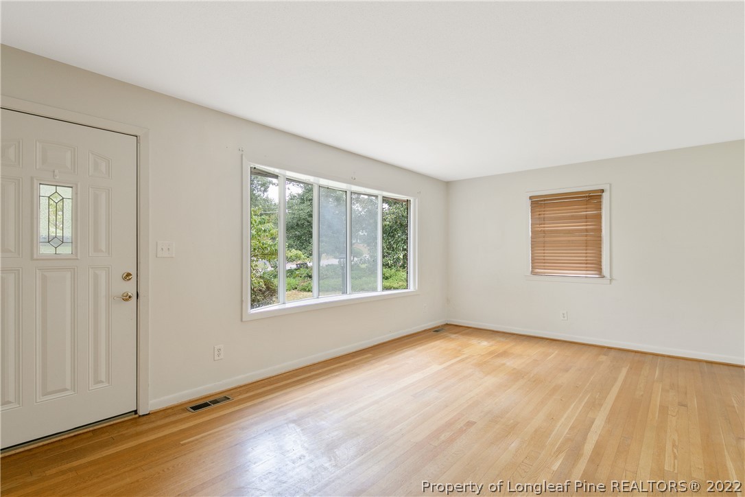 6309 Greyfield Road Fayetteville, NC 28303 - Photo 6 of 45 a view of an empty room with wooden floor and a window