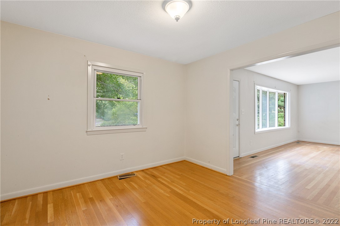 6309 Greyfield Road Fayetteville, NC 28303 - Photo 10 of 45 a view of an empty room with wooden floor and a window