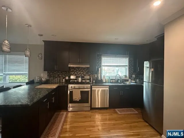 a kitchen with granite countertop stainless steel appliances and wooden cabinets