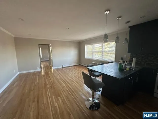 a view of a room with a table chairs and wooden floor