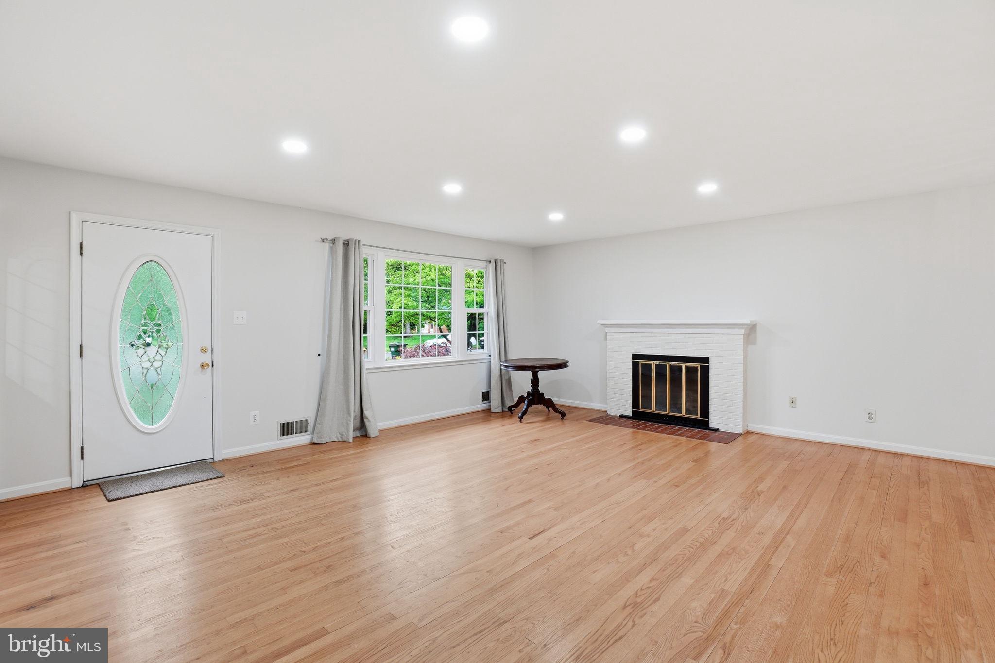 5304 Pillow Lane Springfield, VA 22151 - Photo 5 of 32 an empty room with wooden floor and fireplace