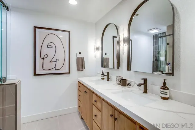 a bathroom with mirror and double vanity