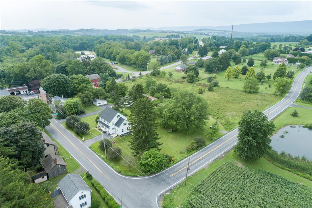 665 Point Phillips Road Bath, PA 18014 - Photo 69 of 73 An aerial perspective reveals a charming home nestled among verdant fields and a tranquil pond, offering a serene rural setting.