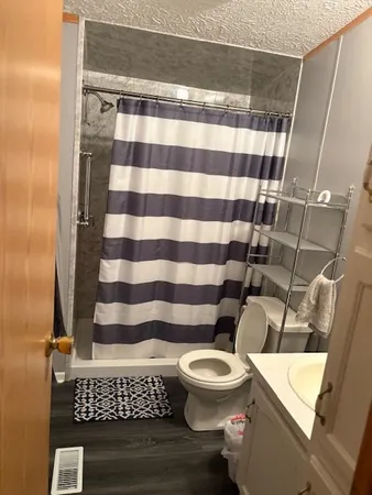 a bathroom with a toilet and a shower