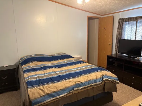 a bedroom with a bed and a flat screen tv