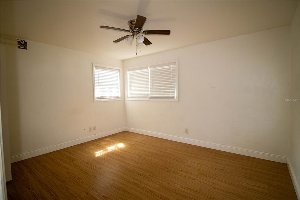 809 Maley Street Daytona Beach, FL 32114 - Photo 11 of 15 an empty room with wooden floor fan and windows