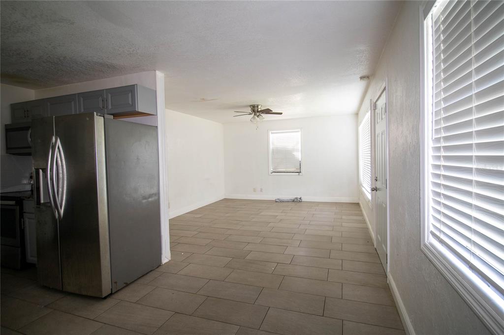 809 Maley Street Daytona Beach, FL 32114 - Photo 5 of 15 a view of a refrigerator in kitchen and an empty room