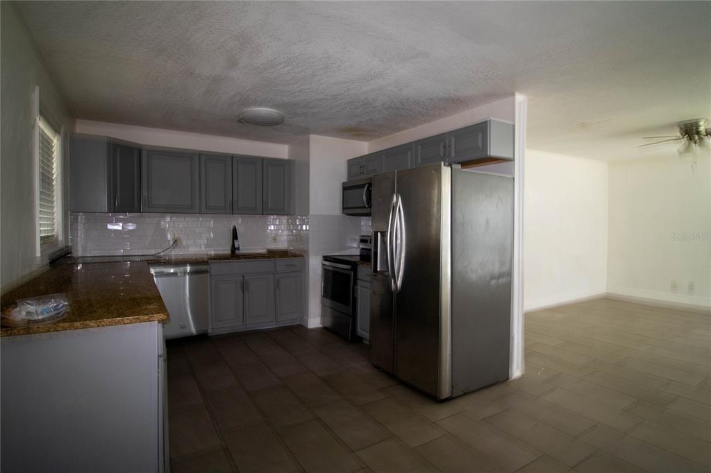 809 Maley Street Daytona Beach, FL 32114 - Photo 8 of 15 a kitchen with a refrigerator sink and cabinets