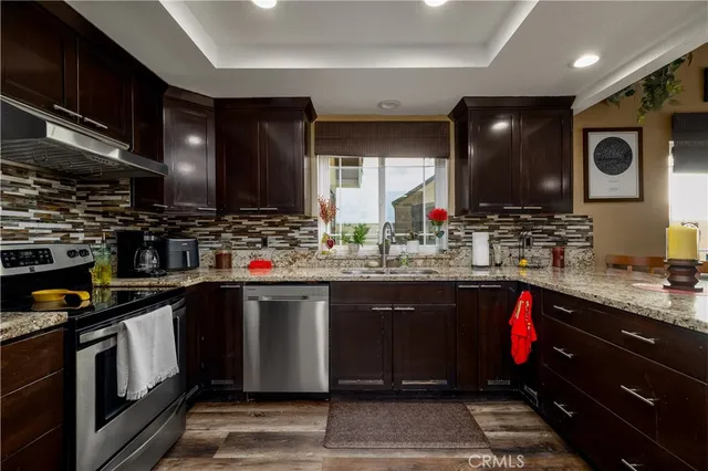 a kitchen with stainless steel appliances kitchen island granite countertop a refrigerator and a stove top oven