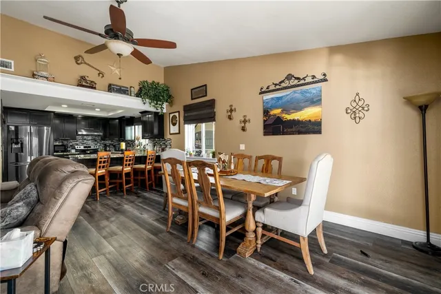 a kitchen with stainless steel appliances granite countertop a table chairs sink refrigerator and microwave