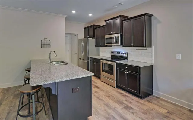 a kitchen with stainless steel appliances granite countertop a stove a sink and a microwave