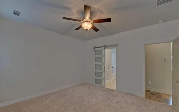 an empty room with closet and a chandelier fan