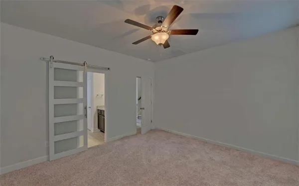an empty room with closet and a ceiling fan