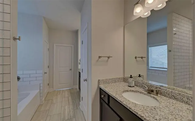 a bathroom with a granite countertop sink and a mirror