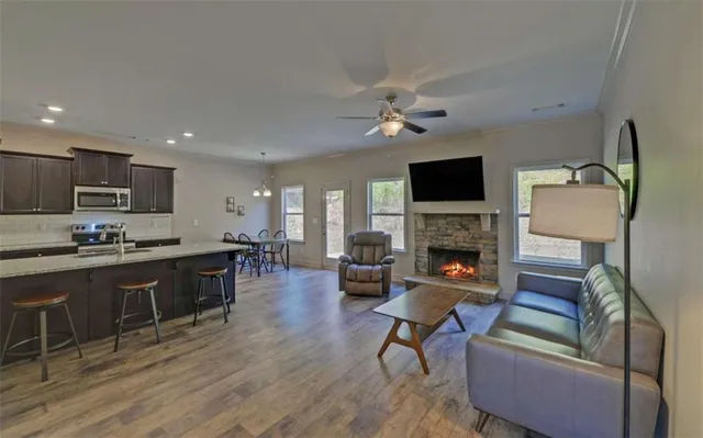 a living room with furniture a fireplace a flat screen tv and kitchen view
