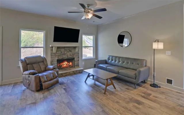 a living room with furniture a flat screen tv and a fireplace