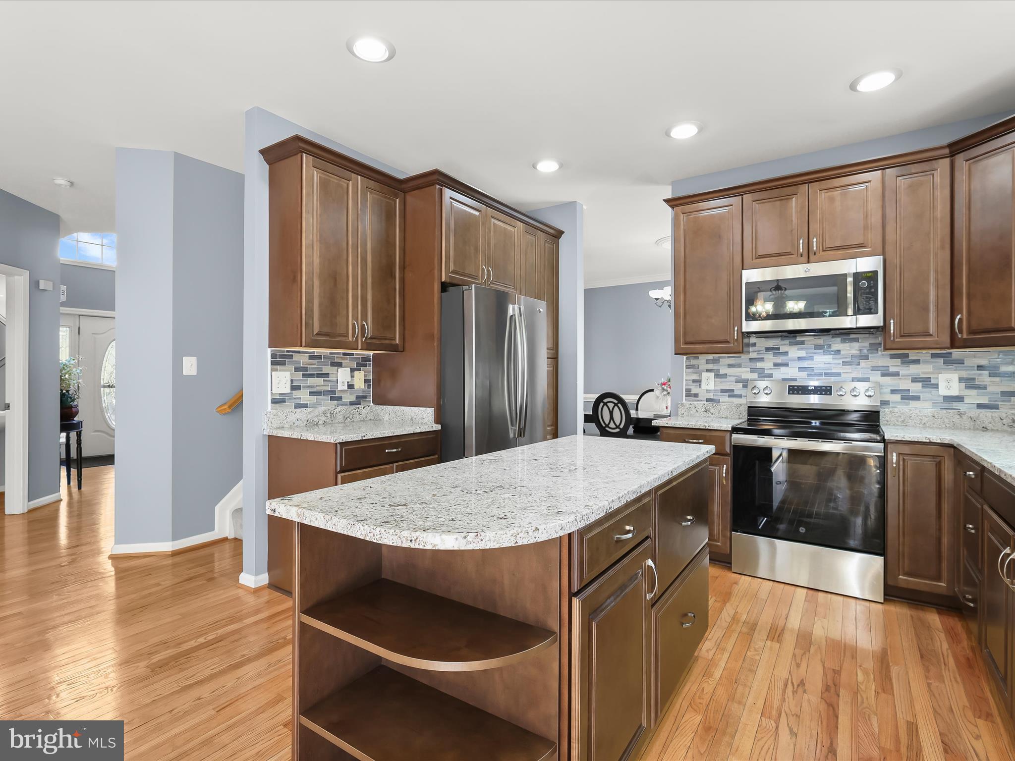 5816 Rockburn Woods Way Elkridge, MD 21075 - Photo 11 of 64 a kitchen with stainless steel appliances granite countertop a stove refrigerator and microwave