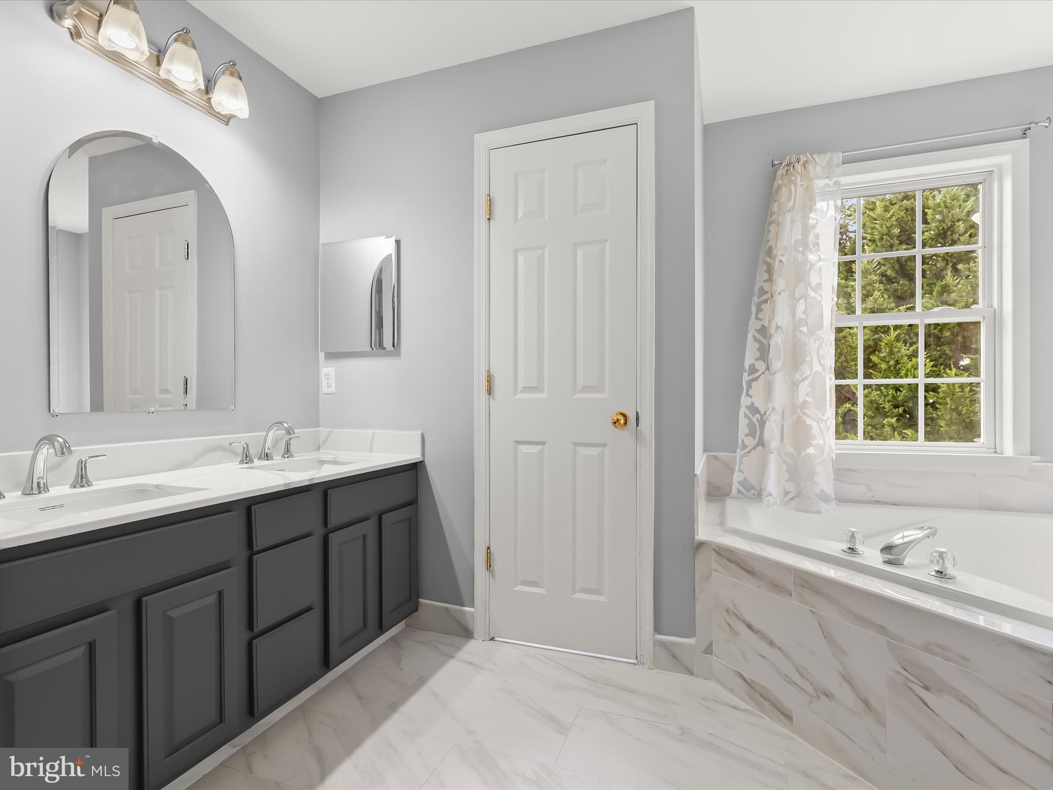 5816 Rockburn Woods Way Elkridge, MD 21075 - Photo 31 of 64 a spacious bathroom with a double vanity sink a large mirror and a bathtub