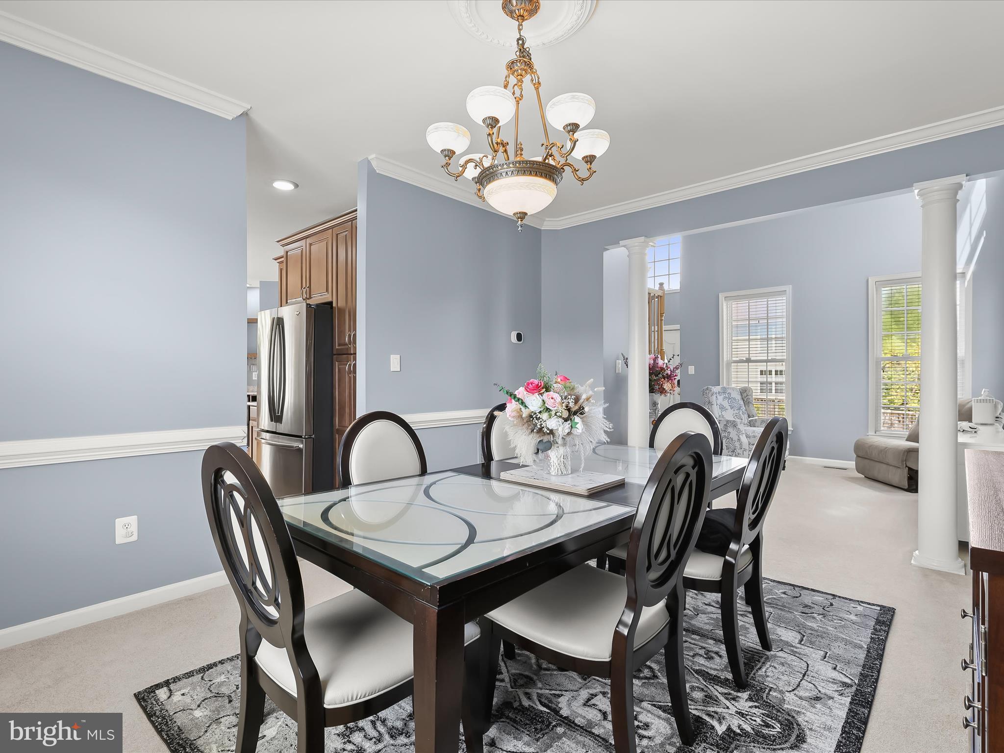 5816 Rockburn Woods Way Elkridge, MD 21075 - Photo 9 of 64 a dining room with wooden floor a chandelier a wooden table and chairs