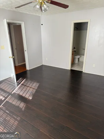 an empty room with wooden floor and staircase