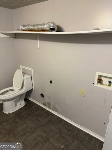 a white toilet sitting next to a sink