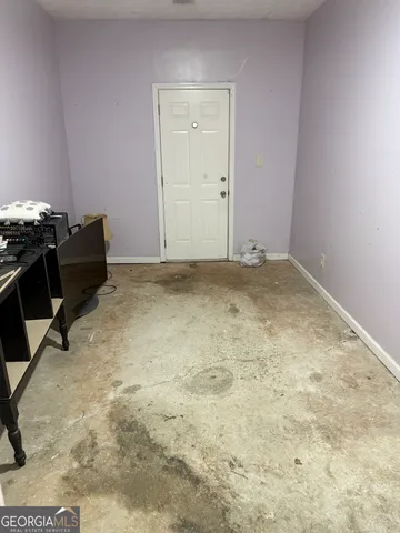a view of a backyard with large trees and wooden fence