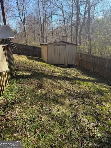 a view of backyard with wooden fence