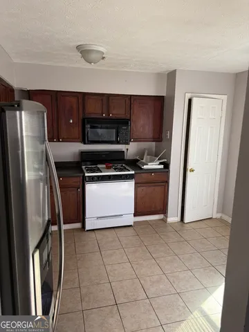 a kitchen with stainless steel appliances granite countertop a stove a refrigerator a sink and dishwasher