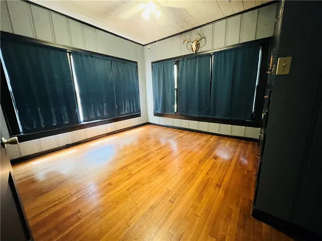 a view of an empty room with wooden floor