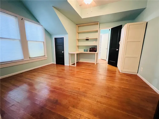a view of empty room with wooden floor and window