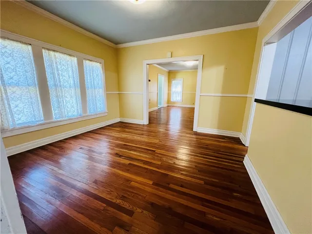 a view of empty room with wooden floor