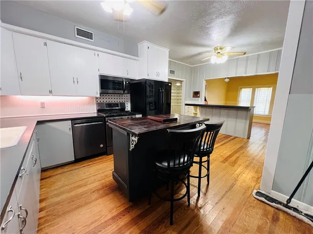 a kitchen with stainless steel appliances a stove a sink dishwasher and a microwave